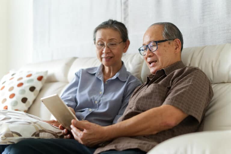 Craft & Communicate | Senior couple looking at their tablet on the couch