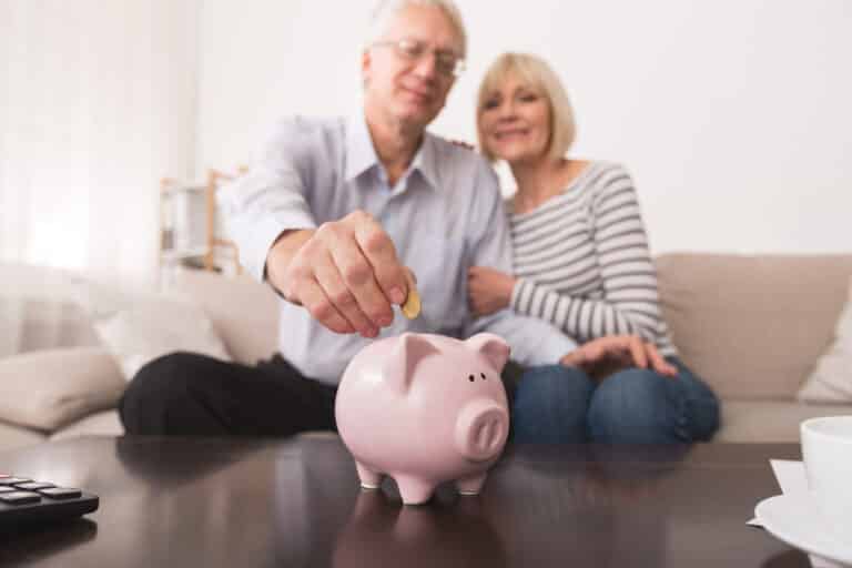 Craft & Communicate | Senior couple saving money in piggybank at home
